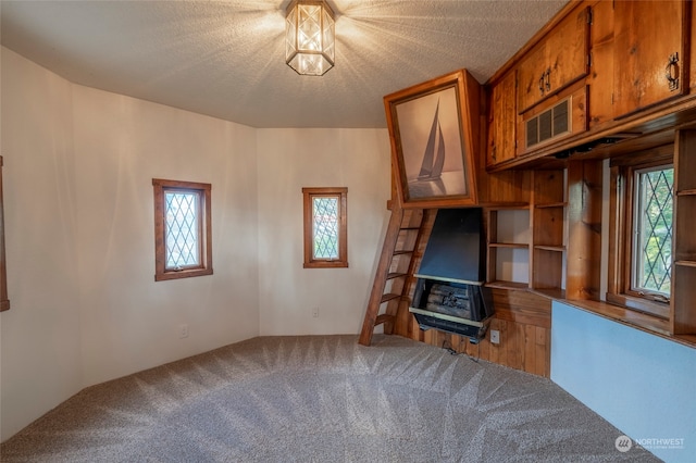 unfurnished living room featuring plenty of natural light and a textured ceiling