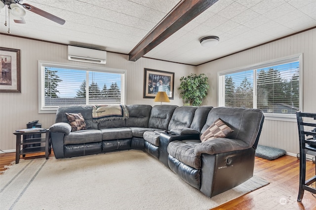 living room with hardwood / wood-style floors, a wall mounted AC, and a healthy amount of sunlight