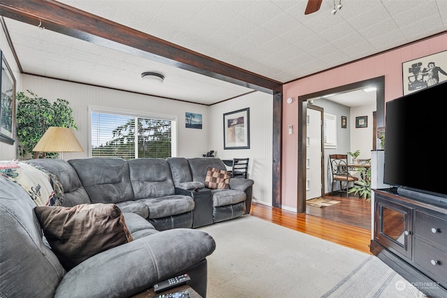 living room featuring ceiling fan, beam ceiling, and wood-type flooring