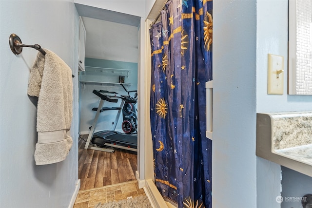 bathroom featuring curtained shower and wood-type flooring