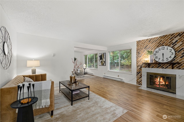 living room featuring a fireplace, hardwood / wood-style floors, a textured ceiling, and a baseboard radiator