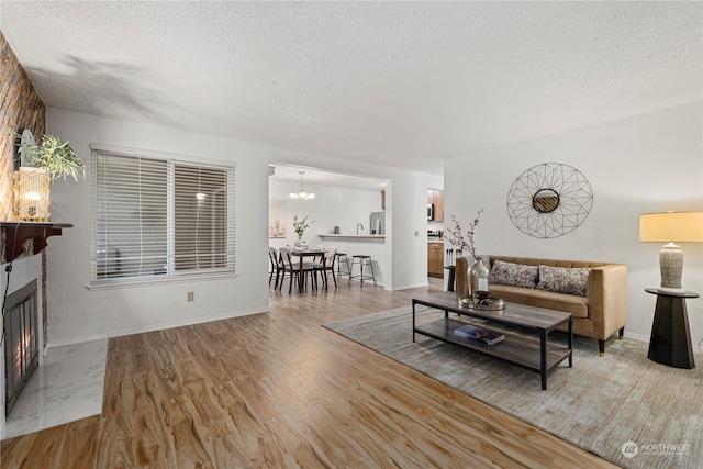 living room with an inviting chandelier, a textured ceiling, and hardwood / wood-style flooring