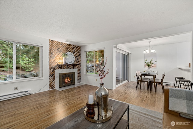 living room with a fireplace, a healthy amount of sunlight, wood-type flooring, and a textured ceiling