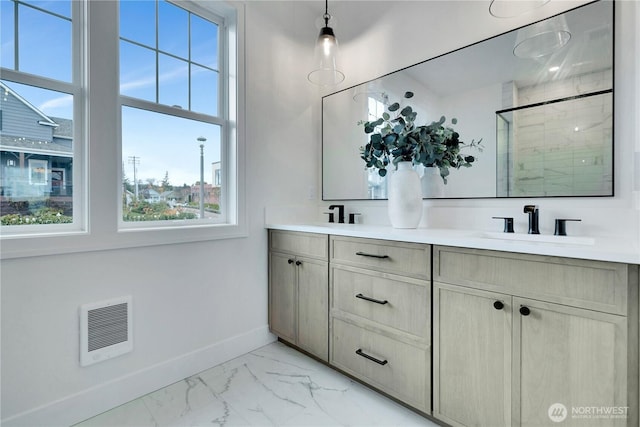 full bath with a stall shower, baseboards, marble finish floor, visible vents, and a sink