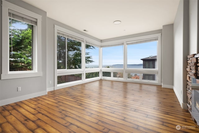 unfurnished sunroom featuring a water view