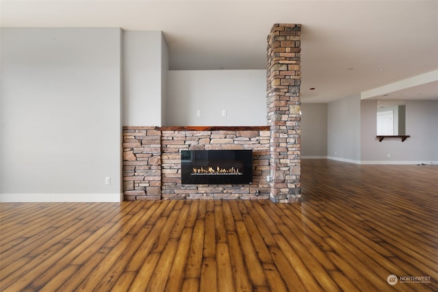 unfurnished living room featuring a stone fireplace and hardwood / wood-style flooring