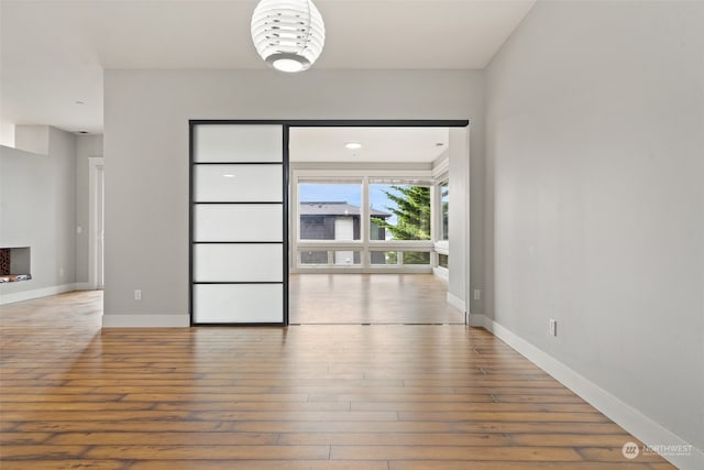 spare room with an inviting chandelier and hardwood / wood-style flooring