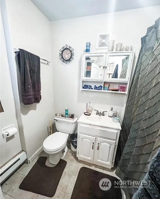 5503 112th St SW, Lakewood, WA 98499 - bathroom with baseboard heating, toilet, vanity, tile patterned floors, and a shower with shower curtain