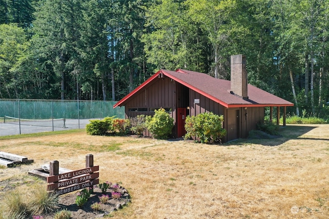 view of side of home featuring an outdoor structure and a lawn