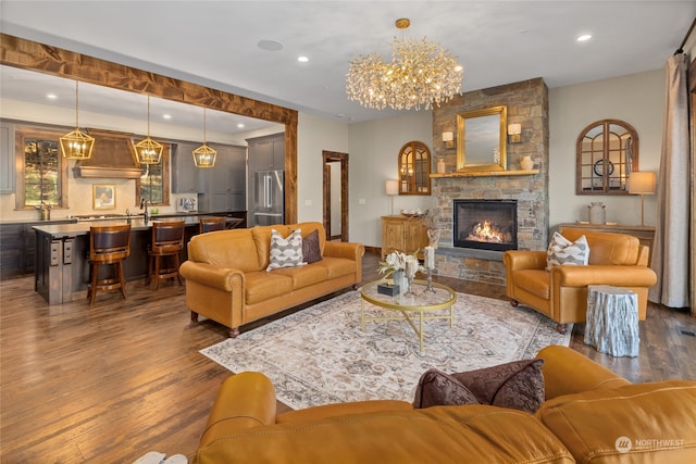 living room with a fireplace, dark wood-type flooring, and a notable chandelier