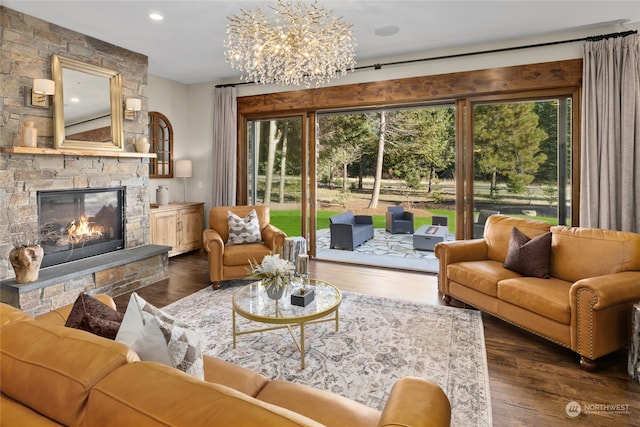 living room with a stone fireplace, dark hardwood / wood-style floors, and a notable chandelier