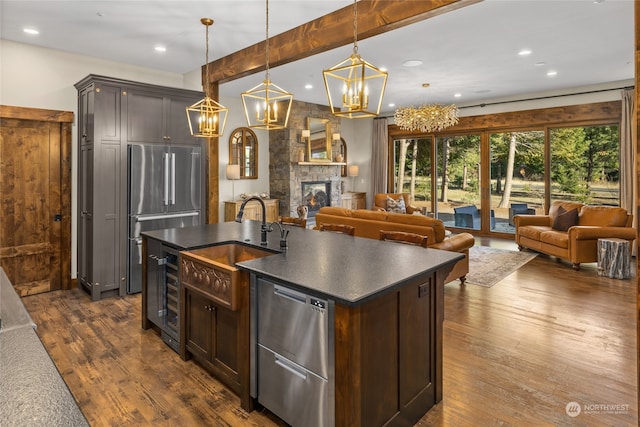 kitchen featuring high quality fridge, dark brown cabinets, a fireplace, and dark hardwood / wood-style floors