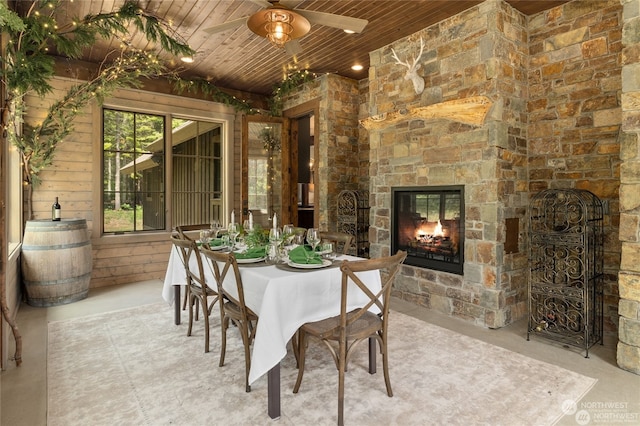 dining space with a fireplace, ceiling fan, and wooden ceiling