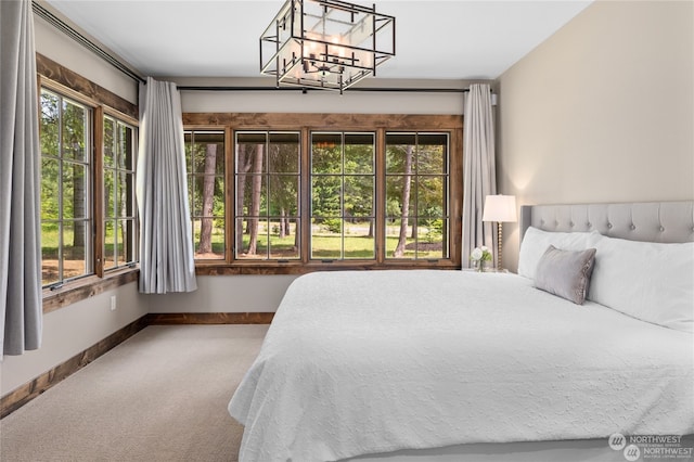 bedroom featuring carpet floors, multiple windows, and a notable chandelier