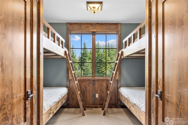 carpeted bedroom with wooden walls