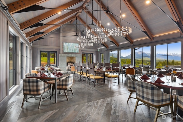 sunroom featuring a notable chandelier, lofted ceiling with beams, a mountain view, and french doors