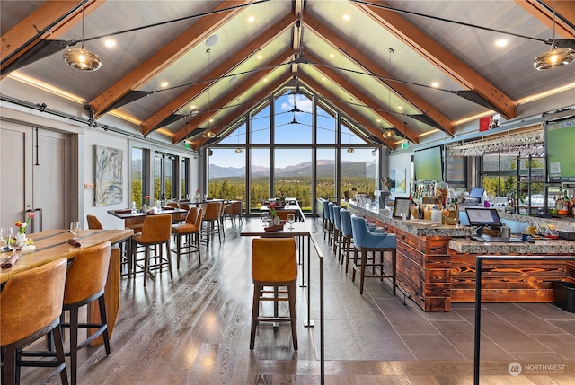 dining area featuring beamed ceiling, a healthy amount of sunlight, hardwood / wood-style floors, and high vaulted ceiling