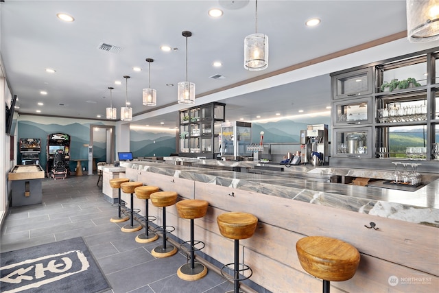 bar featuring decorative light fixtures and light stone counters