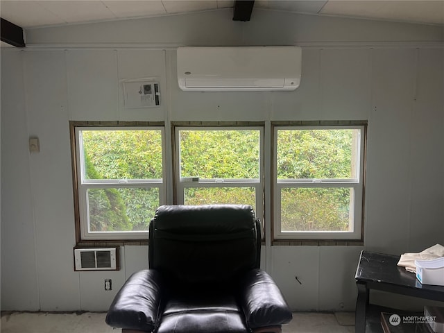 living area with lofted ceiling, an AC wall unit, and a wealth of natural light