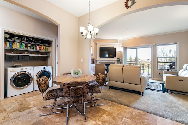 carpeted dining space with a chandelier and washing machine and clothes dryer