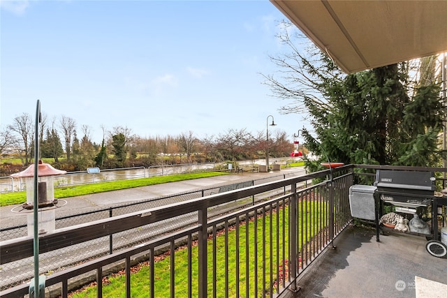 balcony featuring area for grilling and a water view