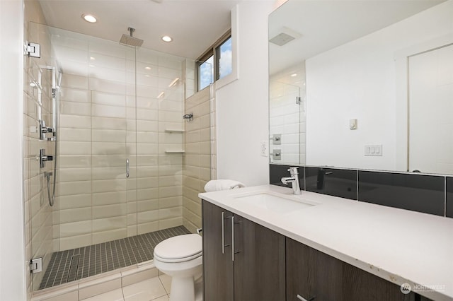 bathroom featuring tile patterned flooring, vanity, a shower with door, and toilet