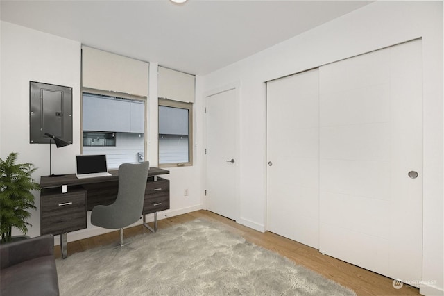 office area featuring electric panel and light hardwood / wood-style flooring