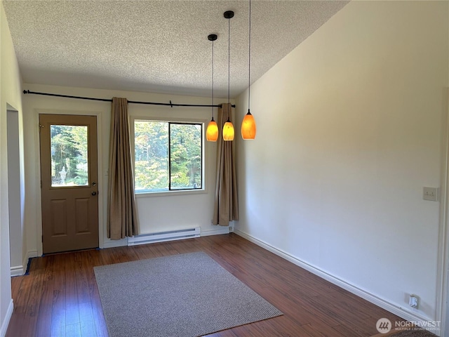 450 Spruce St, Friday Harbor, WA 98250 - unfurnished dining area featuring a baseboard heating unit, a textured ceiling, and wood finished floors