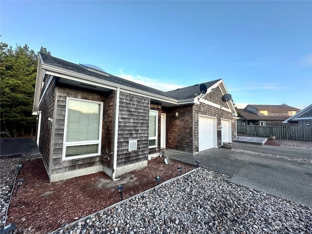 146 28th St NW, Long Beach, WA 98631 - view of home's exterior with fence, driveway, a garage, and roof with shingles