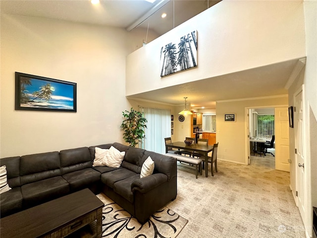 living room with a towering ceiling and light colored carpet