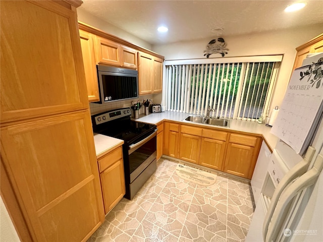 kitchen with backsplash, electric range, and sink