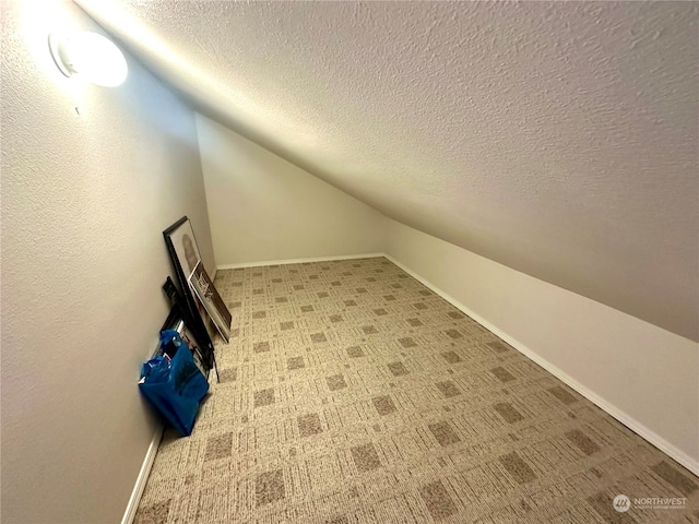 bonus room featuring carpet, a textured ceiling, and lofted ceiling