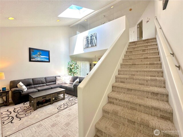 146 28th St NW, Long Beach, WA 98631 - stairway with carpet floors, a skylight, high vaulted ceiling, and plenty of natural light
