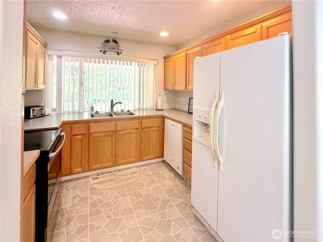 146 28th St NW, Long Beach, WA 98631 - kitchen with white appliances, a sink, light countertops, recessed lighting, and light stone finish flooring