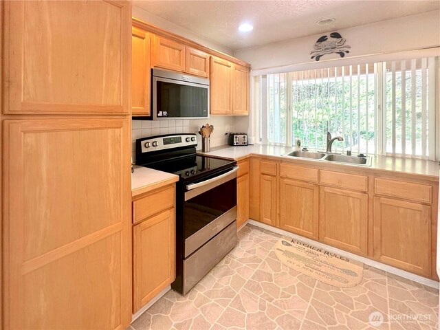 146 28th St NW, Long Beach, WA 98631 - kitchen with appliances with stainless steel finishes, a sink, light brown cabinetry, light countertops, and recessed lighting
