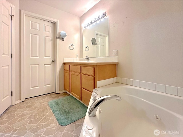 146 28th St NW, Long Beach, WA 98631 - bathroom with vanity, a tub with jets, and stone finish floors