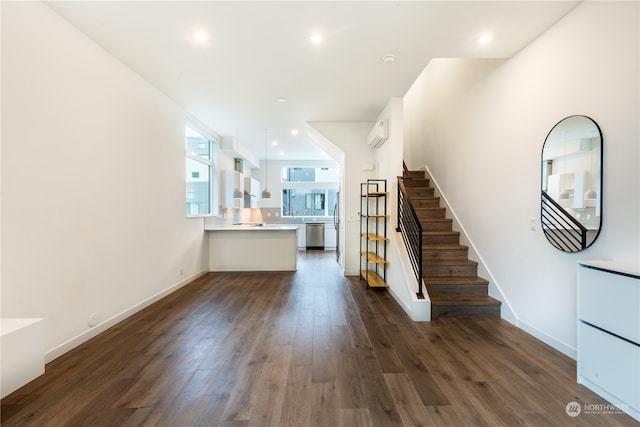 unfurnished living room featuring dark hardwood / wood-style floors and a wall unit AC