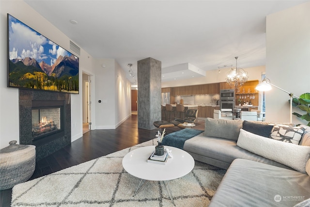 living room featuring a chandelier and dark wood-type flooring