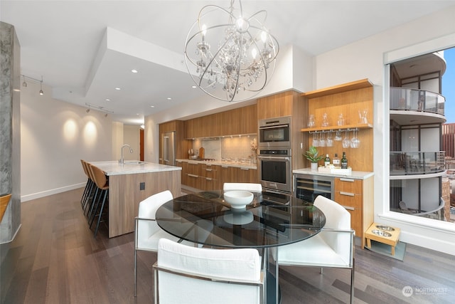 dining room with dark hardwood / wood-style floors, wine cooler, a notable chandelier, and sink