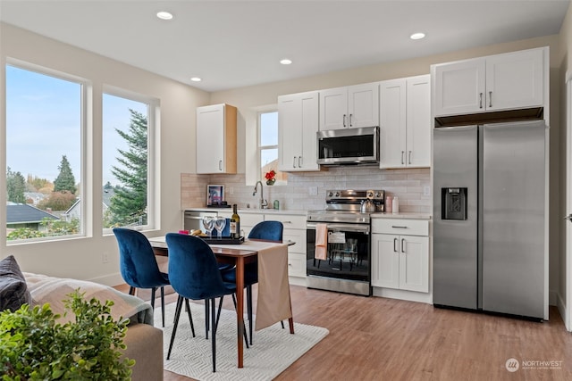 kitchen featuring plenty of natural light, white cabinetry, and appliances with stainless steel finishes