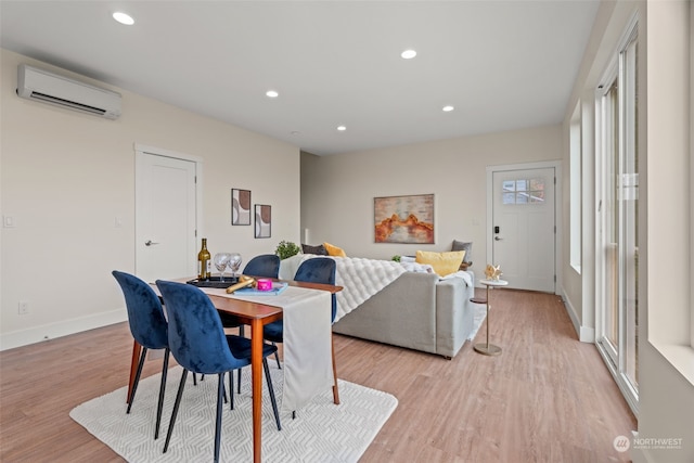 dining space featuring a wall mounted AC and light hardwood / wood-style floors