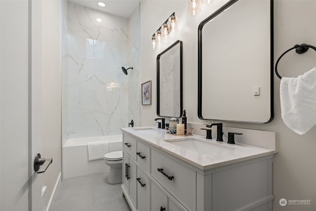 full bathroom featuring tiled shower / bath, vanity, and toilet