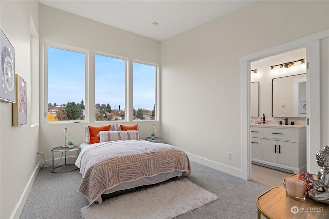 bedroom with ensuite bath and light carpet