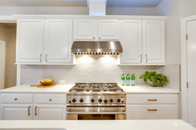 kitchen with white cabinetry, wall chimney range hood, and high end stainless steel range