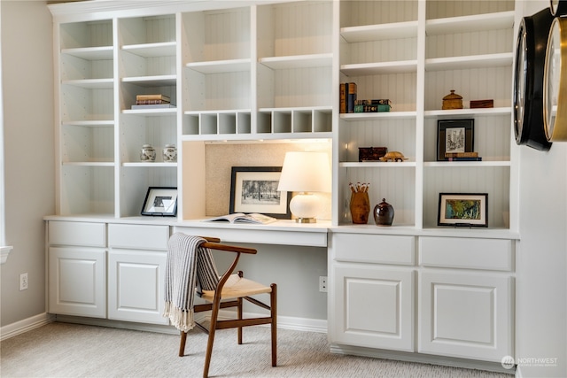 home office featuring light carpet and built in desk