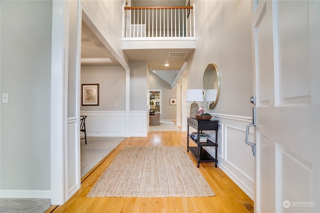 foyer with beamed ceiling and light hardwood / wood-style floors