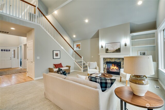 carpeted living room featuring a fireplace and a high ceiling