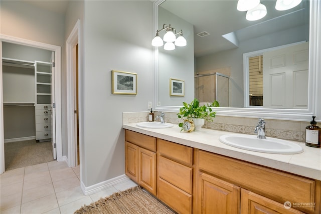 bathroom with tile patterned floors, vanity, and a shower with door