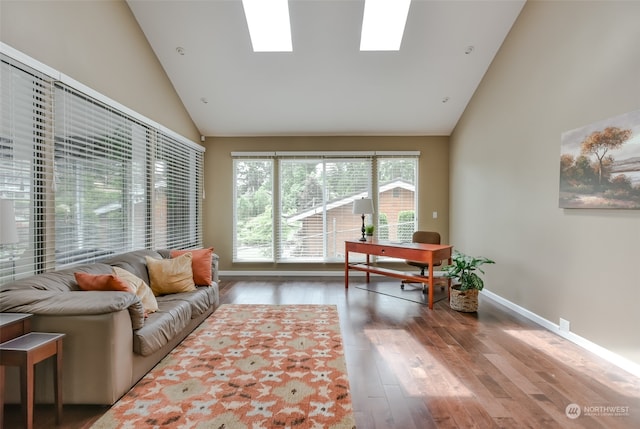 living room featuring a skylight, hardwood / wood-style floors, and high vaulted ceiling