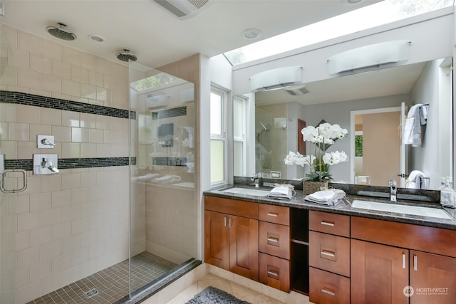 bathroom with a wealth of natural light, tile patterned flooring, vanity, and an enclosed shower